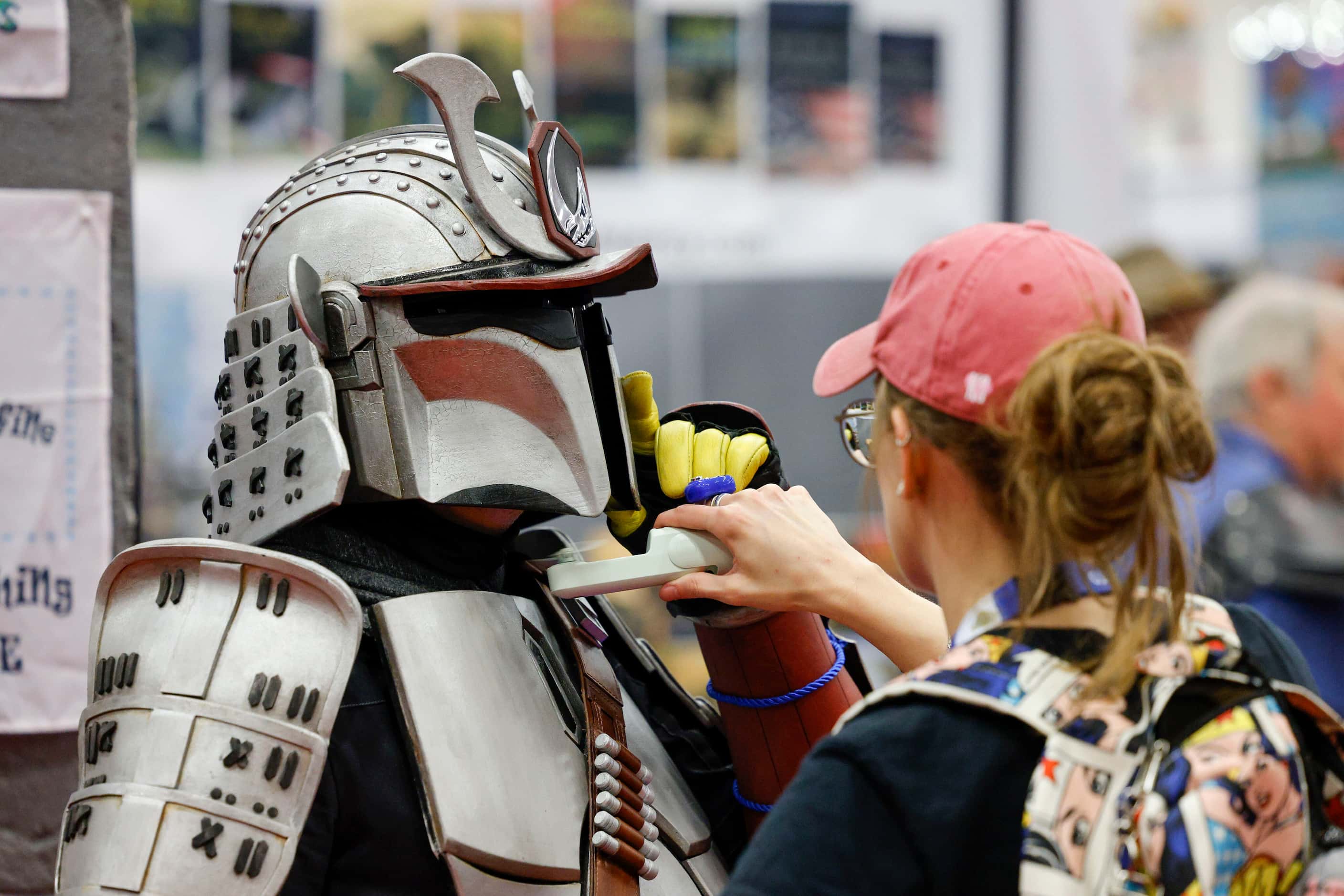 Matt Ronan dressed as Ronin Mandalorian lifts his mask for a cool breeze from his partner...