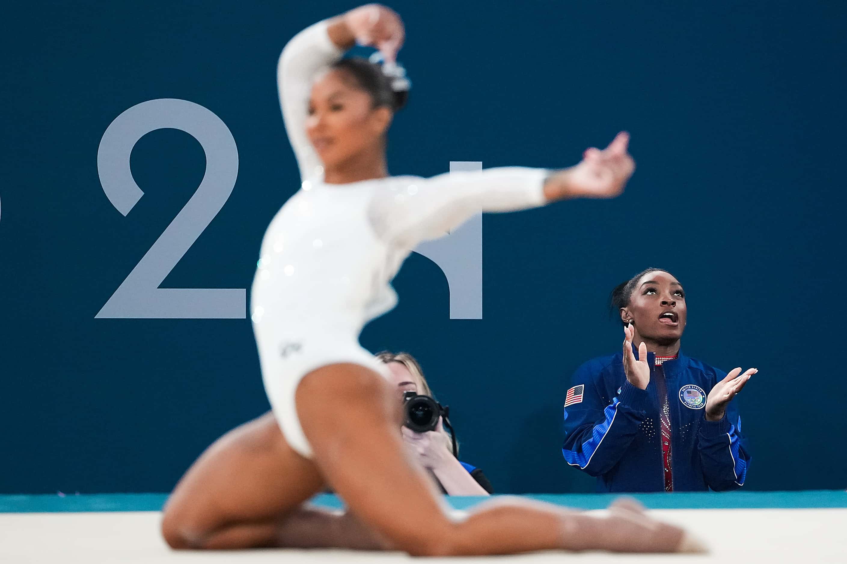 Simone Biles cheers Jordan Chiles of the United States competes in the women’s floor...