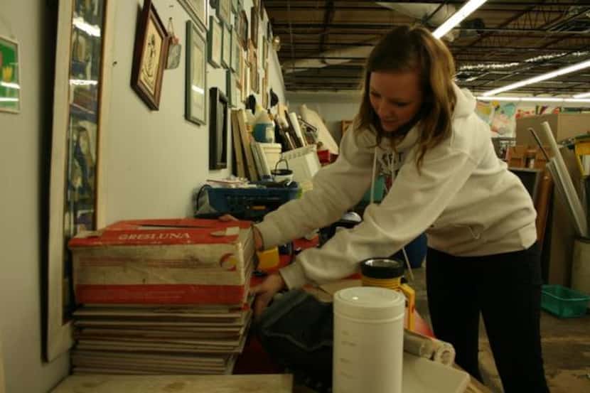 
Urban Thrift employee Erika Jones organizes a table of merchandise in the back of the Lake...