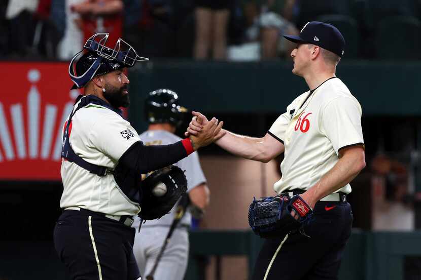 Texas Rangers catcher Sandy Leon (12) celebrates with relief pitcher Josh Sborz (66) after...