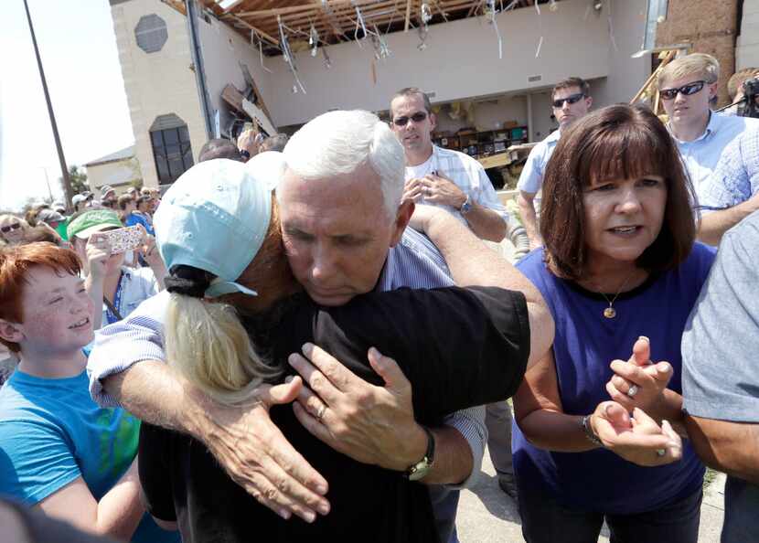 Vice President Mike Pence, center, with his wife Karen, right, shares a hug as he tries to...