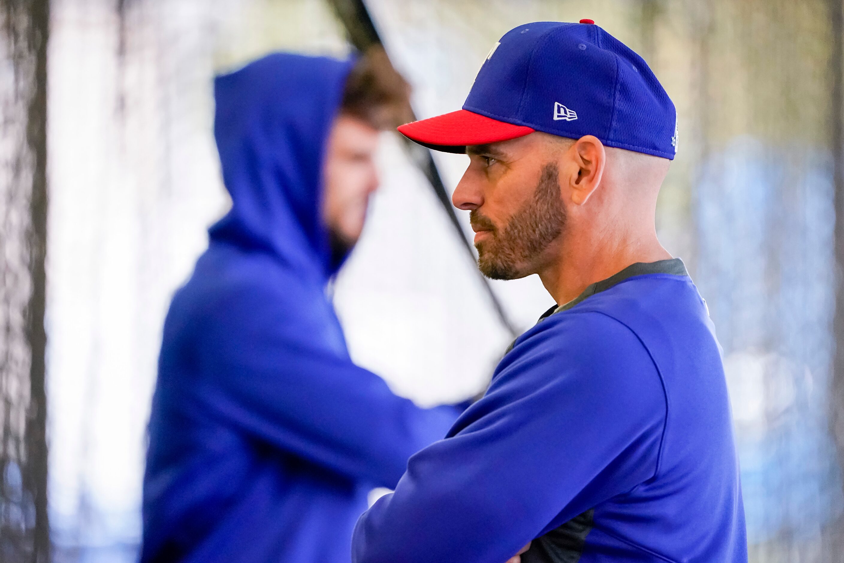 Texas Rangers watches players hit in the batting cages on the day pitchers and catchers...