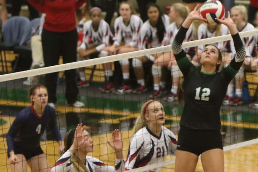 Southlake Carroll's Lisie Kit (12) skies as she sets a teammate over the defense of Allen...