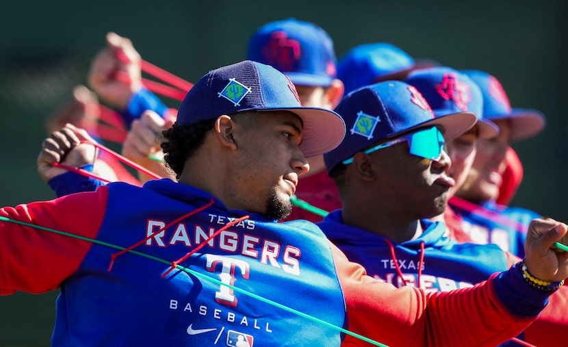 Infielder Maximo Acosta stretches with teammates, including infielder Luisangel Acuna...