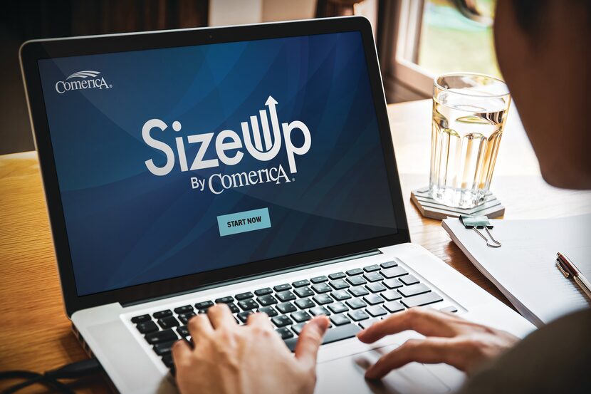 Person working on a laptop with SizeUp by Comerica displayed on the screen.