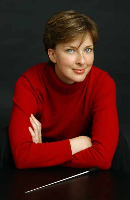 Hart Institute Alumna Elizabeth Askren poses in a red sweater with a conductor's baton in...