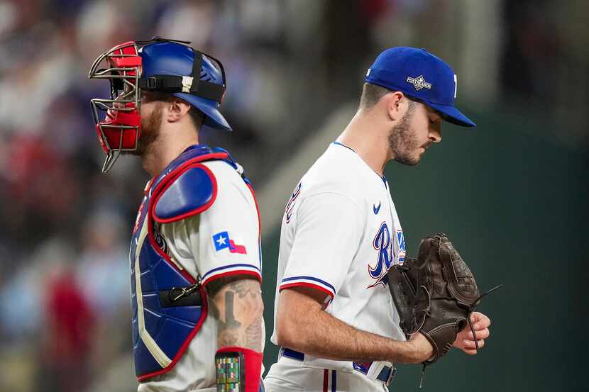 Texas Rangers pitcher Cody Bradford gets a visit from catcher Jonah Heim after a home run by...