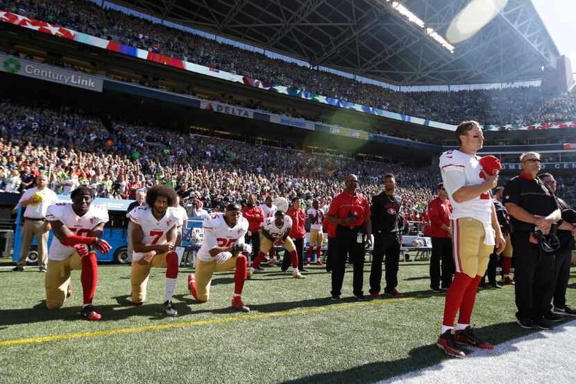  San Francisco 49ers Blaine Gabbert, right, stands as Eli Harold (58), Colin Kaepernick (7)...
