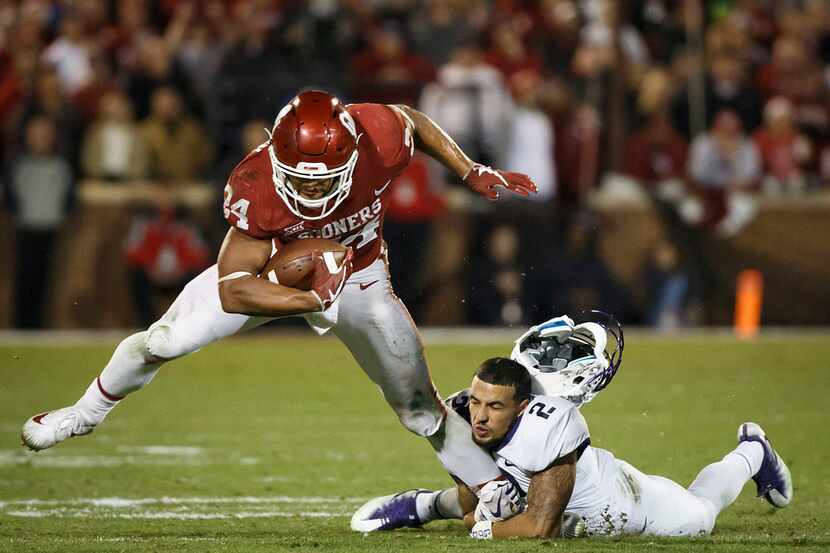 TCU safety Niko Small (2) has his helmet knocked off as he tries to bring down Oklahoma...