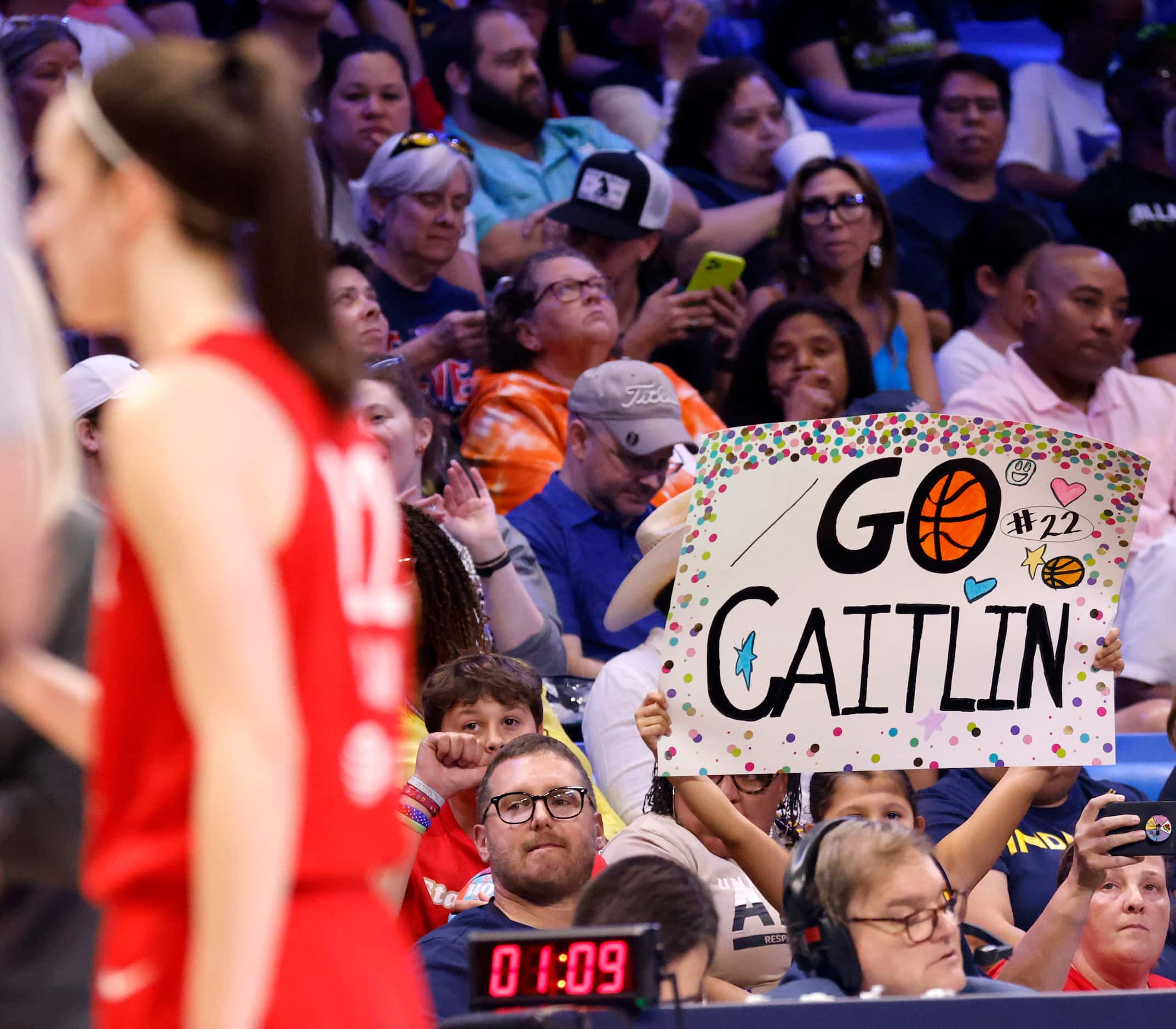 A found fan shows her support for Indiana Fever guard Caitlin Clark (left) during their game...