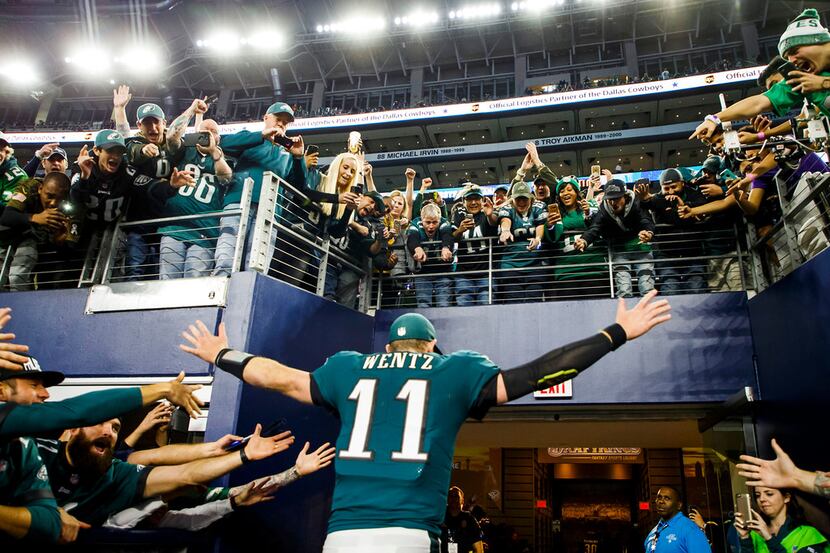 Philadelphia Eagles quarterback Carson Wentz (11) celebrates with fans as he leaves the...