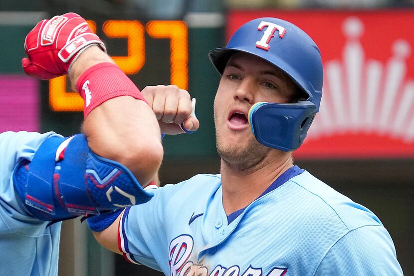 Texas Rangers third baseman Josh Jung celebrates with left fielder Robbie Grossman after...