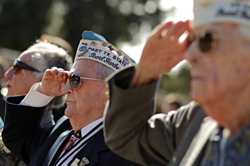 Pearl Harbor survivor Robert Tanner (second from left) saluted the flag during the Pledge of...