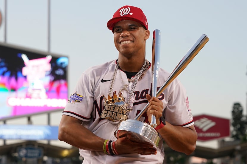National League's Juan Soto, of the Washington Nationals, holds the winner's trophy after...