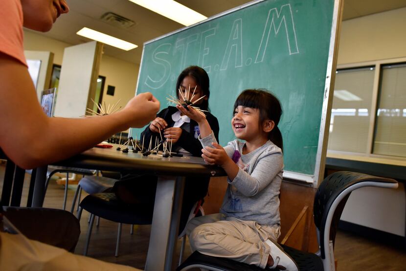 First-grader Layla Puente reacts with a smile as she shows off her creation to tutor...