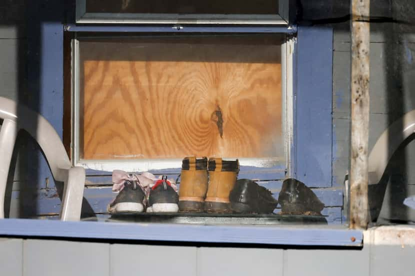 Three pairs of shoes sit in an enclosed porch on Saturday, March 4, 2023, at the home where...