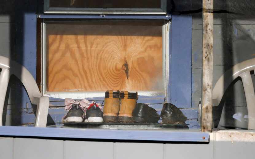 Three pairs of shoes sit in an enclosed porch on Saturday, March 4, 2023, at the home where...
