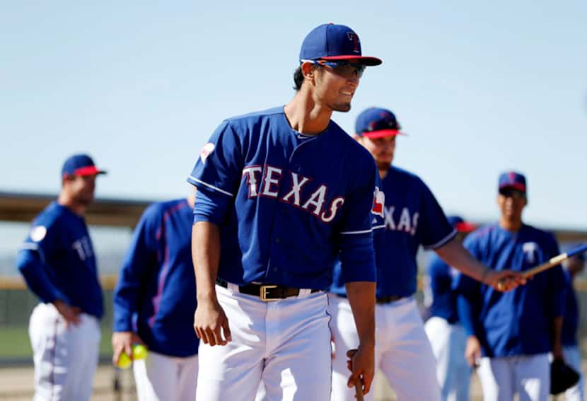  Texas Rangers pitcher Yu Darvish grins before hitting during a softball mock hitting and...