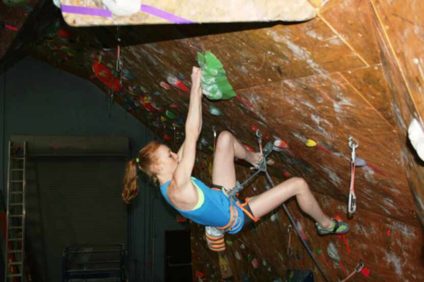 Delaney Miller carefully places a toe on a hold while working through a sport climbing route...