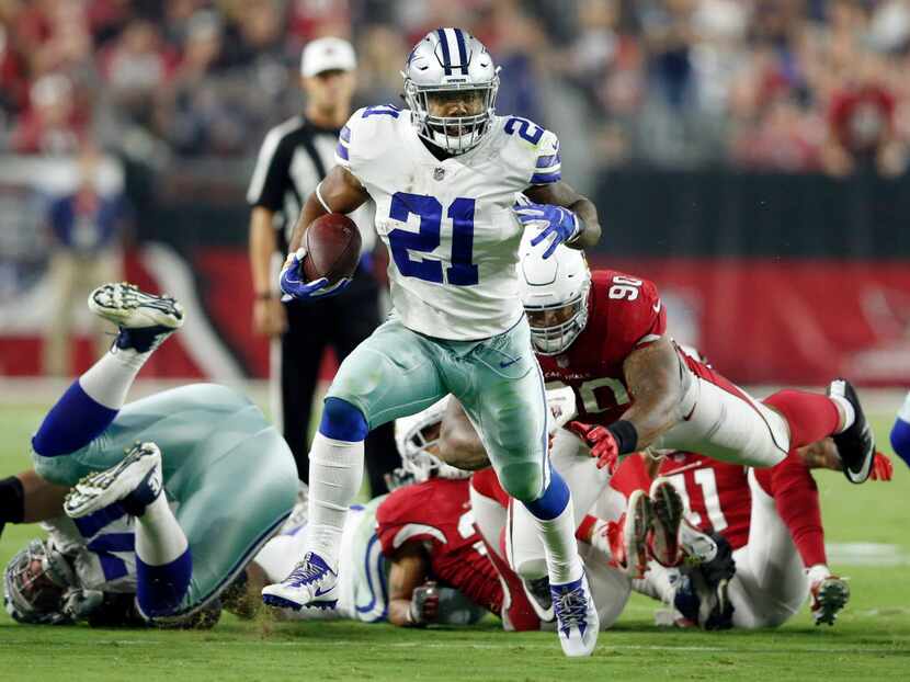 Dallas Cowboys running back Ezekiel Elliott (21) runs up the field after passing by Arizona...