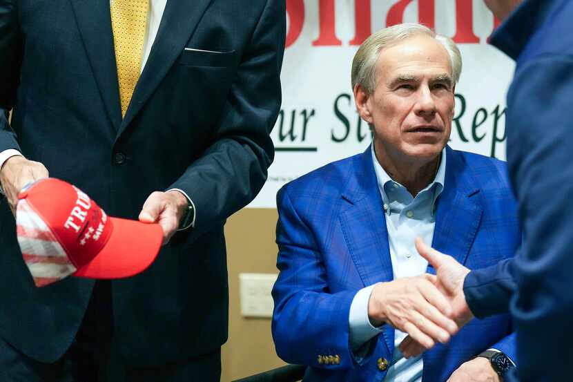 Texas Gov. Greg Abbott greets supporters at a campaign event for state Rep. Matt Shaheen...