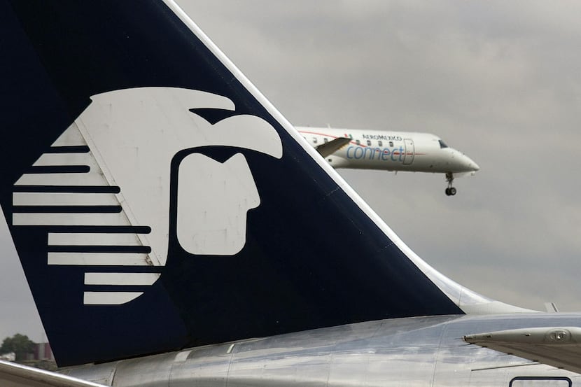 The Grupo Aeromexico SAB logo is seen on the tail of a plane as another jet takes off from...