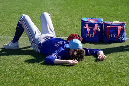 Texas Rangers pitcher Andrew Heaney relaxes on a practice field before the first full squad...