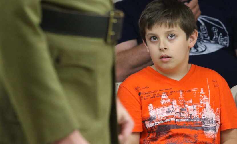 
Caleb Tosch, 8, looks on as his father Jeremy Tosch performs with the Mesquite Community...