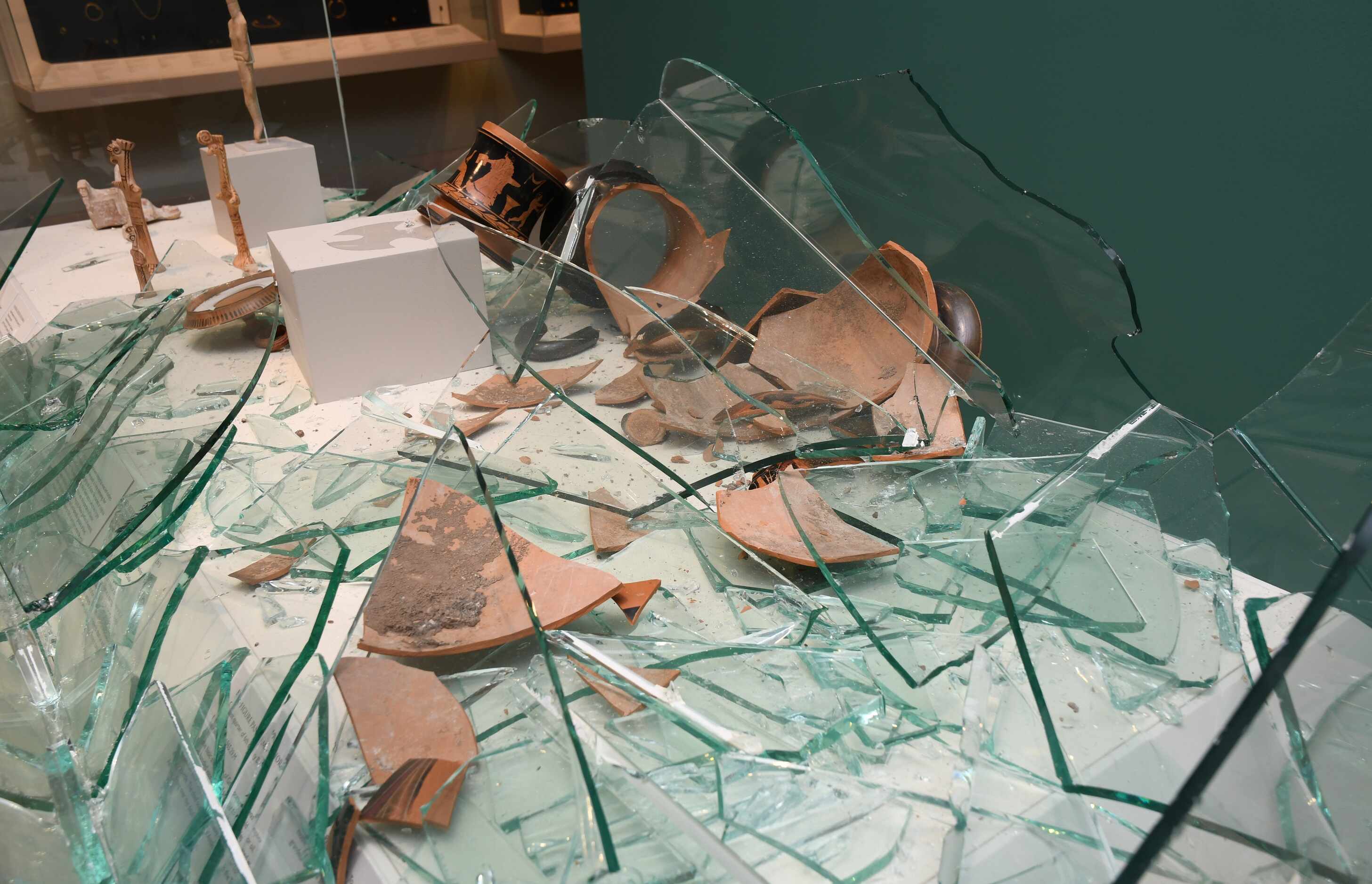 Shards of the amphora Hernandez allegedly broke are shown scattered across a display case.
