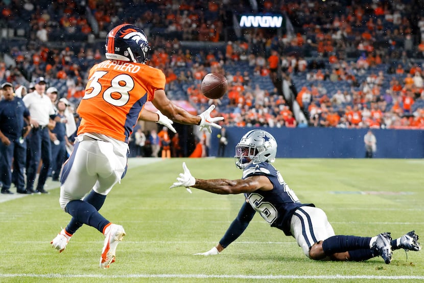 Dallas Cowboys cornerback Kyron Brown (26) looks back after nearly intercepting a pass...