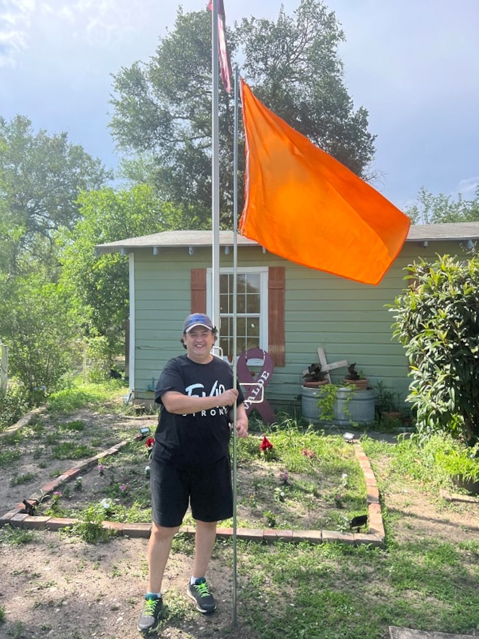 Teacher Arnulfo Reres who survived the shooting at Robb Elementary School holds a flag like...