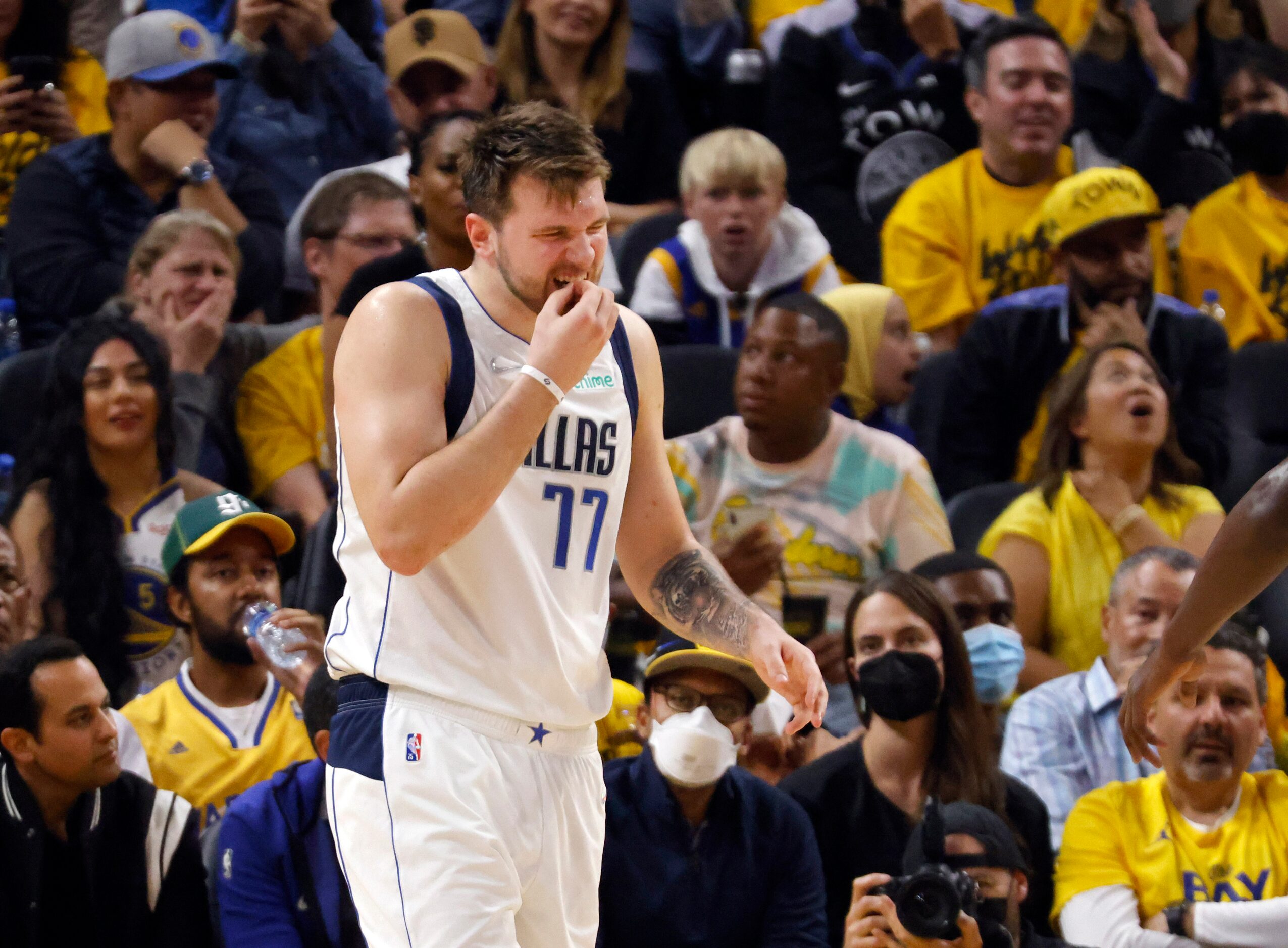 Dallas Mavericks guard Luka Doncic (77) holds his front teeth after being hit in the mouth...