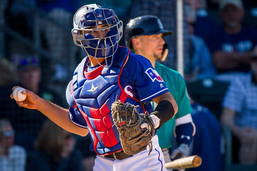 Texas Rangers catcher Isiah Kiner-Falefa makes a throw back to the pitcher during the...