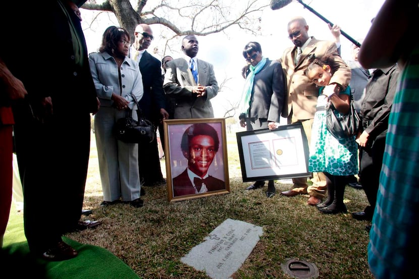 
Members of Timothy Cole’s family stands with his mother, Ruby Session, center, at his grave...