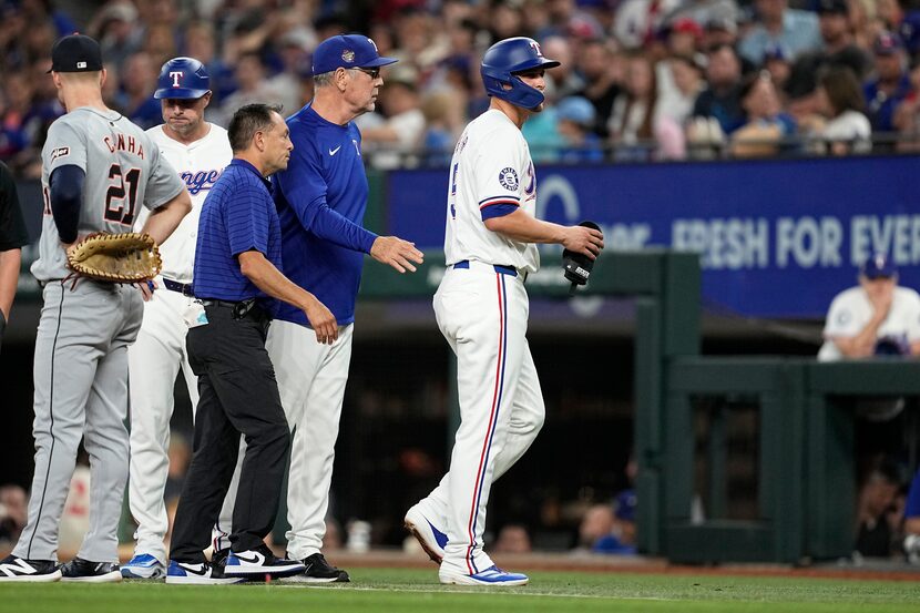 Texas Rangers' Corey Seager, right, is followed off the field by manager Bruce Bochy and...