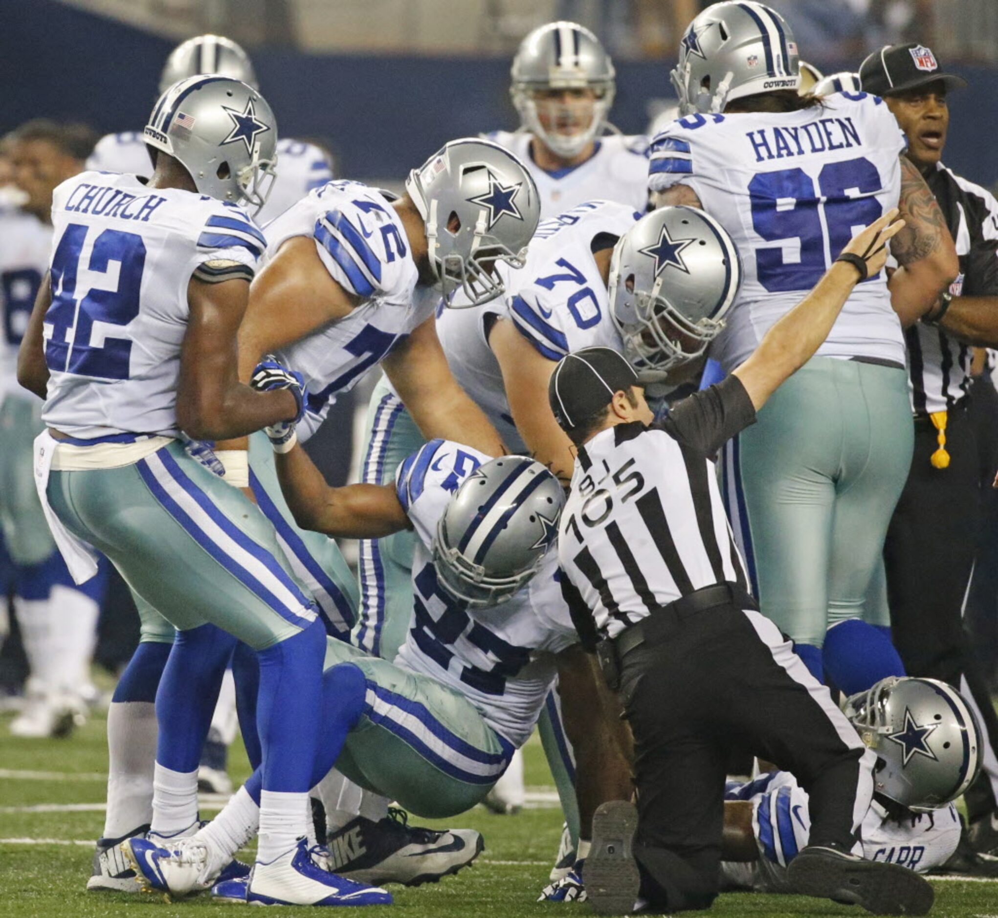 Teammates help Dallas Cowboys strong safety J.J. Wilcox (27) to his feet after the Cowboys...