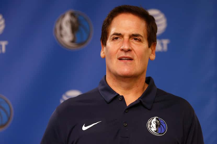 Dallas Mavericks owner Mark Cuban stands on stage before Cynthia Marshall, new interim CEO...