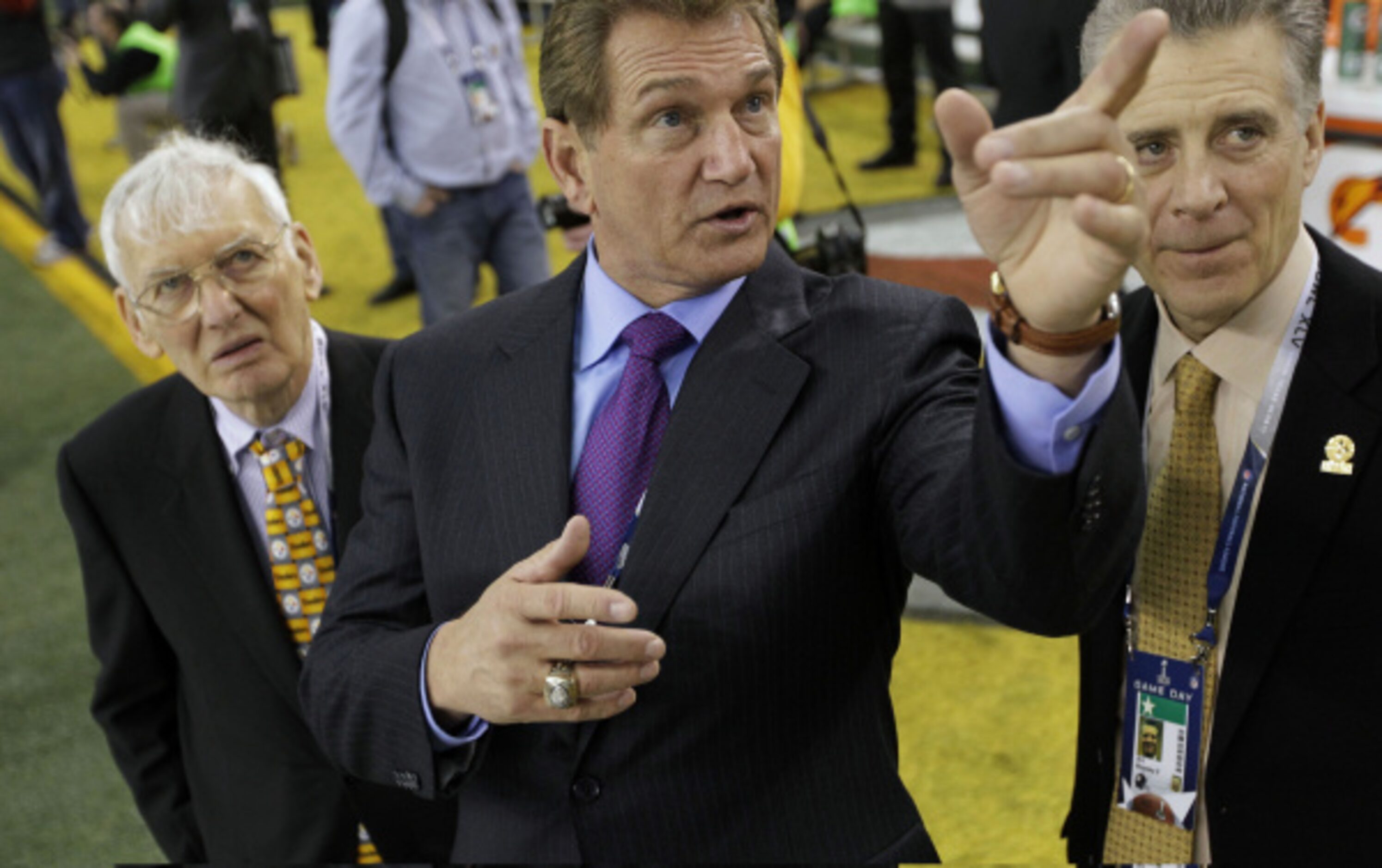 Former NFL quarterback and sportscaster Joe Theismann, center, shows off Cowboys Stadium to...