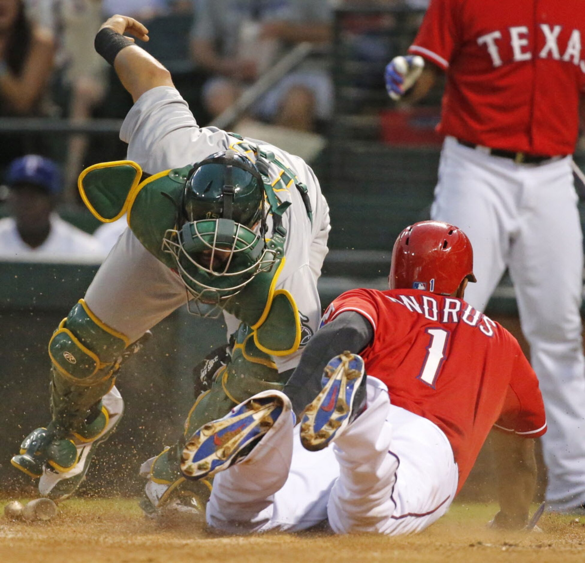 Texas' Elvis Andrus slides home safely on a first inning hit by Rougned Odor, as Oakland...