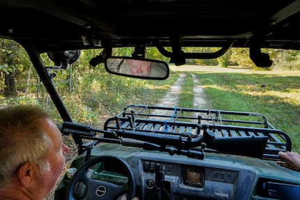 With a hunting rifle handy on their Kawasaki Mule, Bill and Joyce Wilson drive through their...