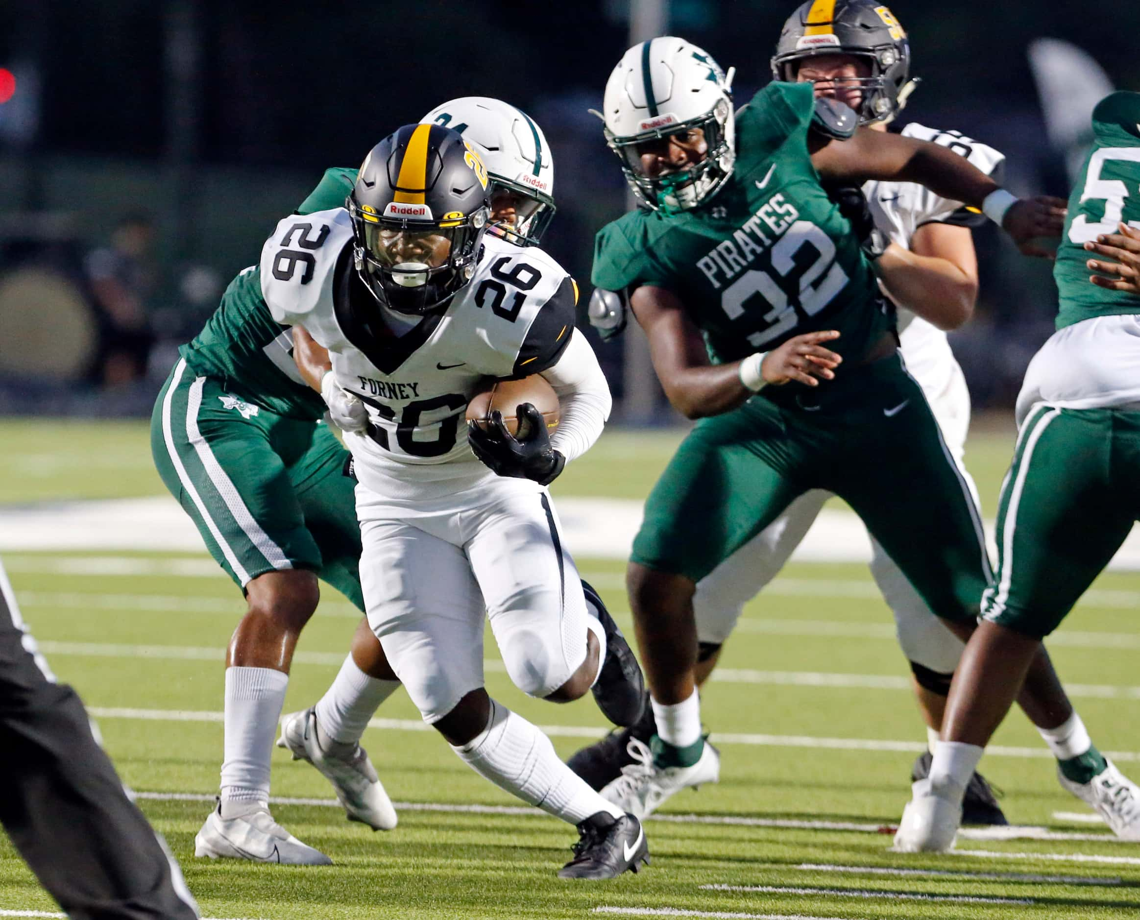 Forney High RB Javian Osborne (26) breaks through the Mesquite Poteet high line in route to...