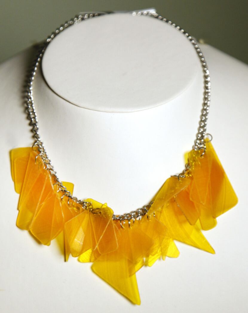 This yellow charm necklace is made from pieces of a colorful record album.