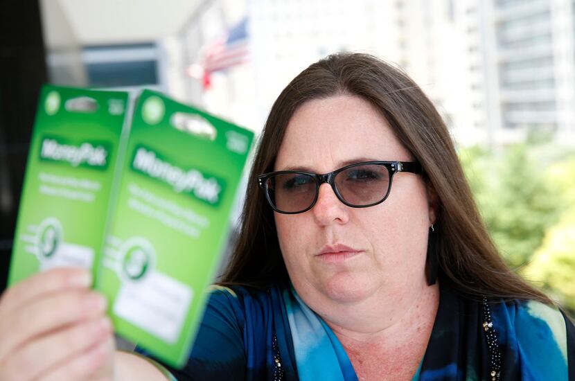Jennifer Smallwood holds the pre-paid cards valued at $400 that her husband was about to pay...