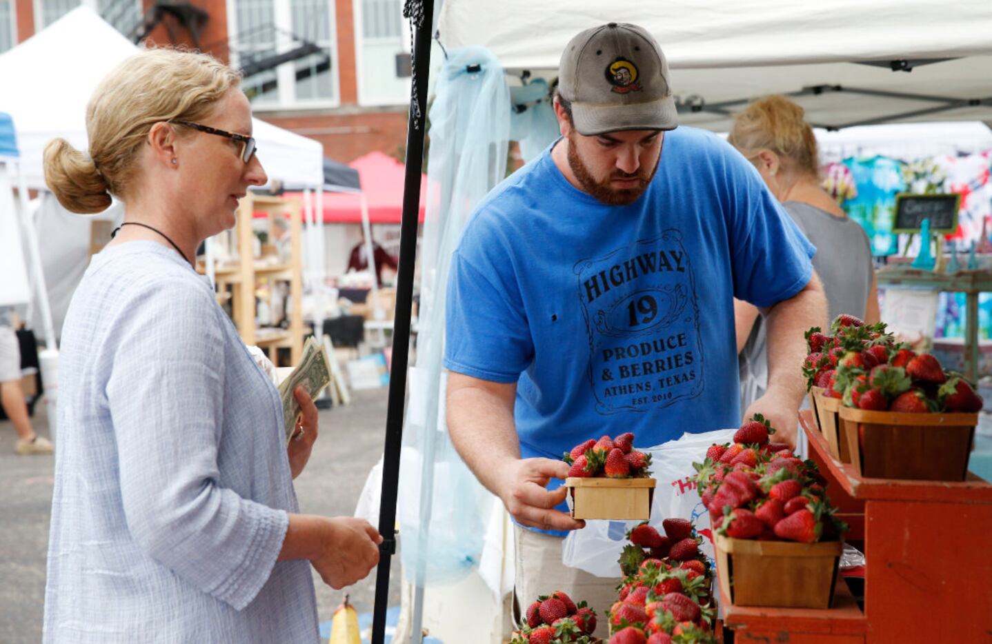 Bobby Bever bags strawberries for Sarah Perry at the Highway 19 Produce and Berries booth.