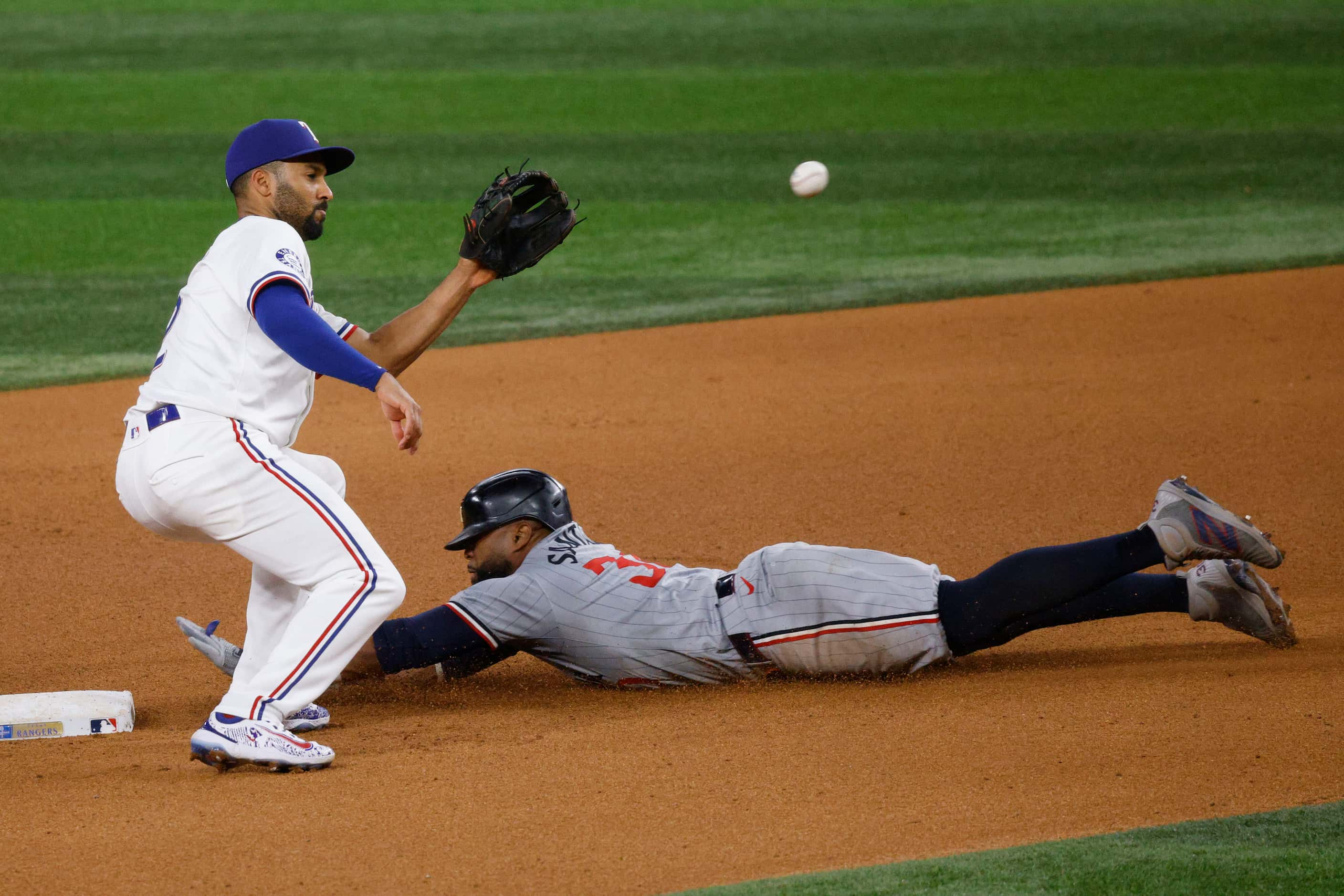 Minnesota Twins first base Carlos Santana (30) steals second base as Texas Rangers second...