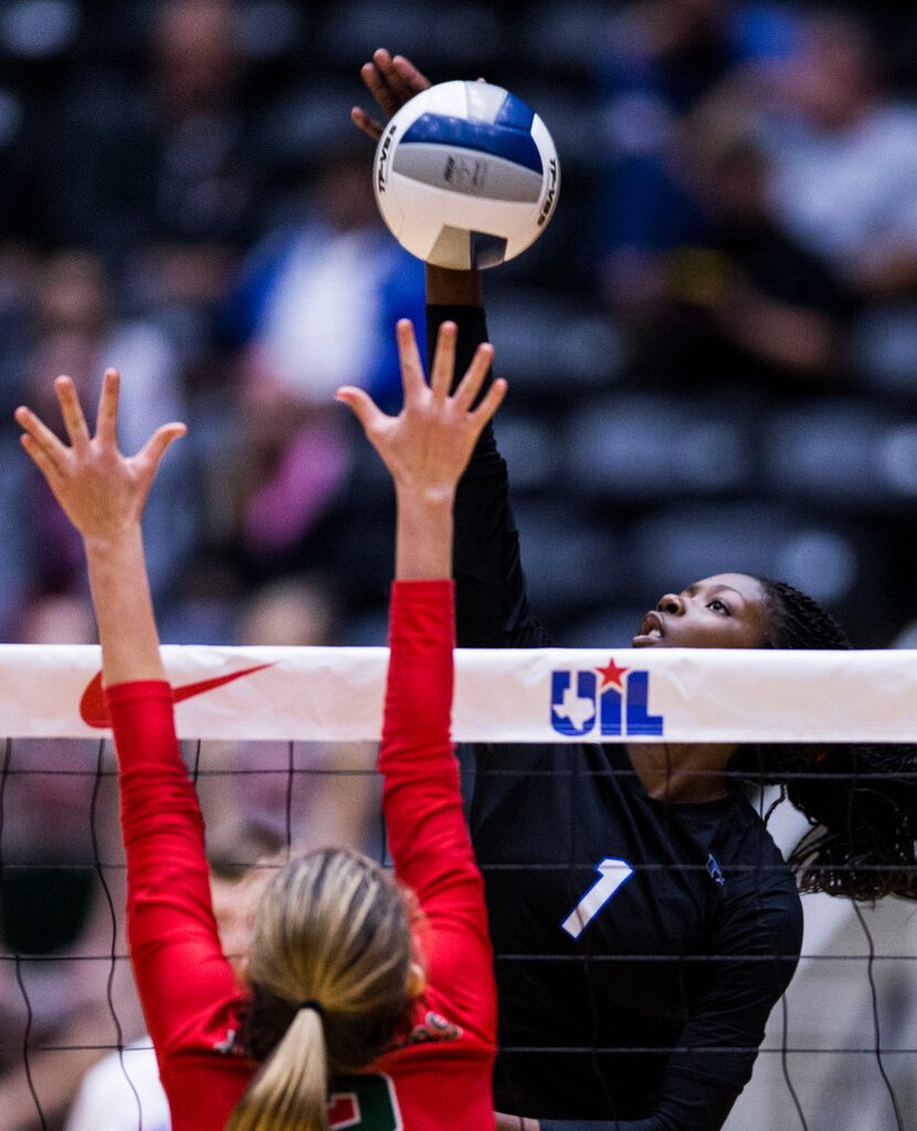 Hebron's Adanna Rollins (1) spikes the ball past The Woodlands' Ally Haden (2) during the...