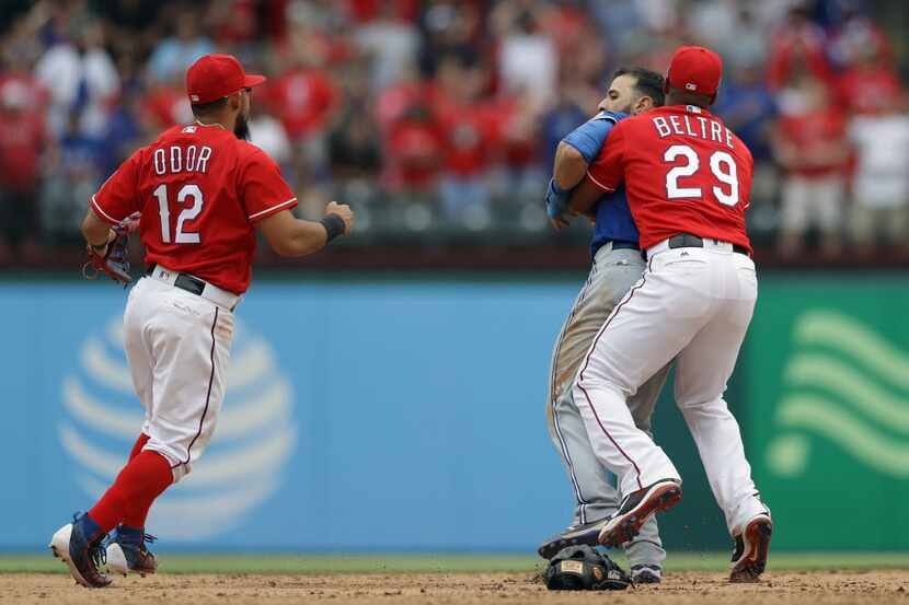 Adrian Beltre #29 of the Texas Rangers holds Jose Bautista #19 of the Toronto Blue Jays...
