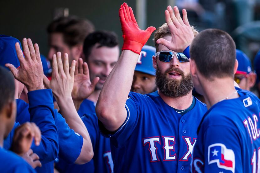 Texas Rangers infielder Matt Davidson gets a hand outfielder Carlos Tocci after hitting a...