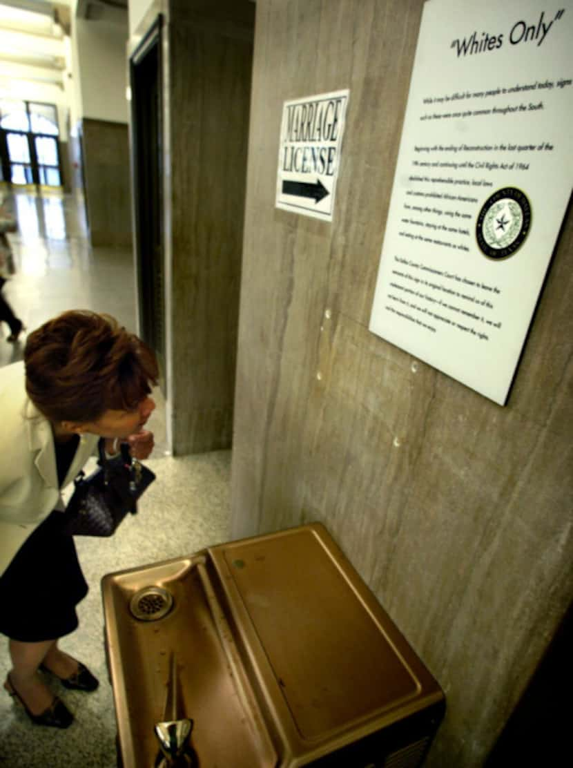 The “Whites Only” sign over a water fountain in the Dallas County Records Building was faint...