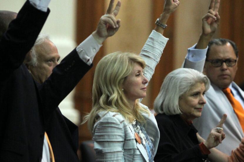 State Senator Wendy Davis celebrates with colleagues as bedlam breaks out near midnight on...